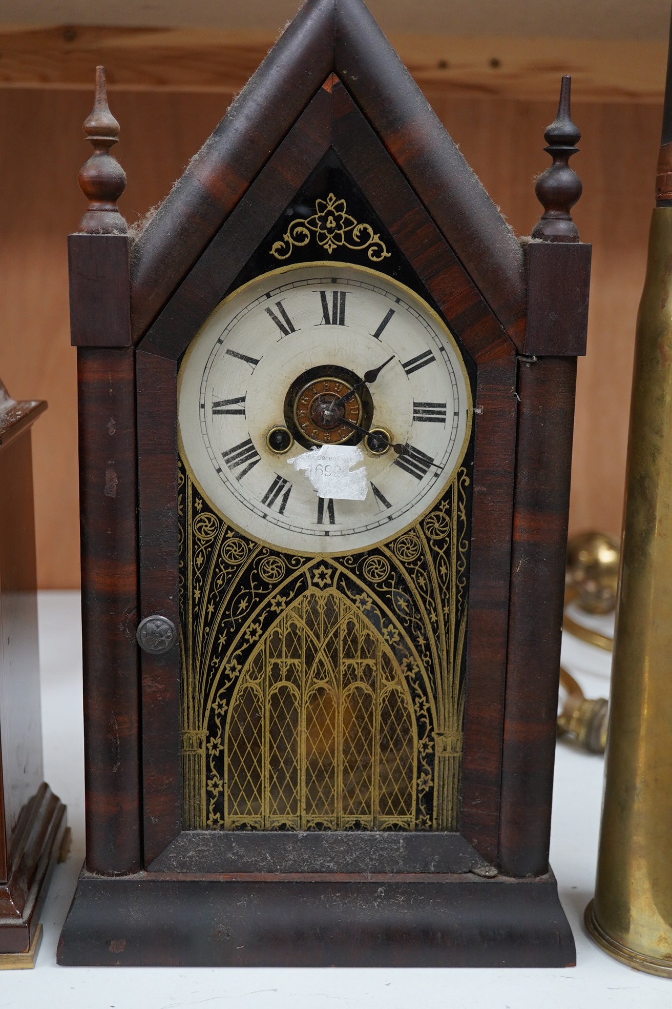 Two clocks including an American example, with keys and two military interest brass shells. Condition - fair